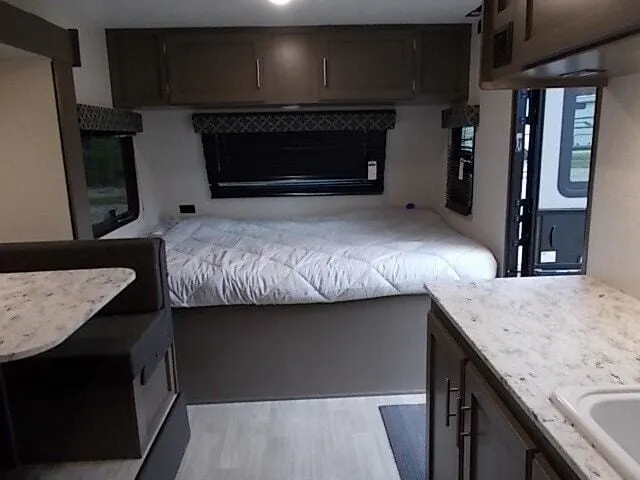 Bedroom with a queen size bed and overhead cabinets.