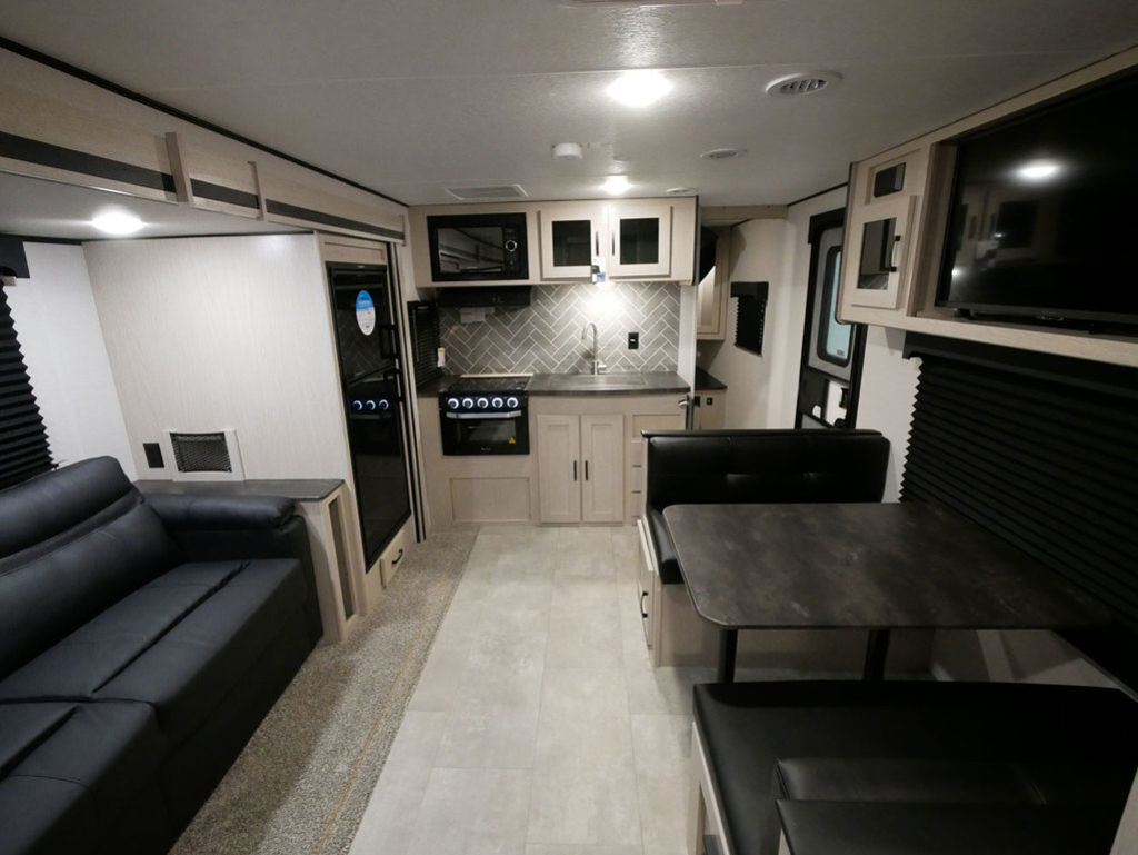 Interior view of the RV with a dinette, living space and a kitchen.