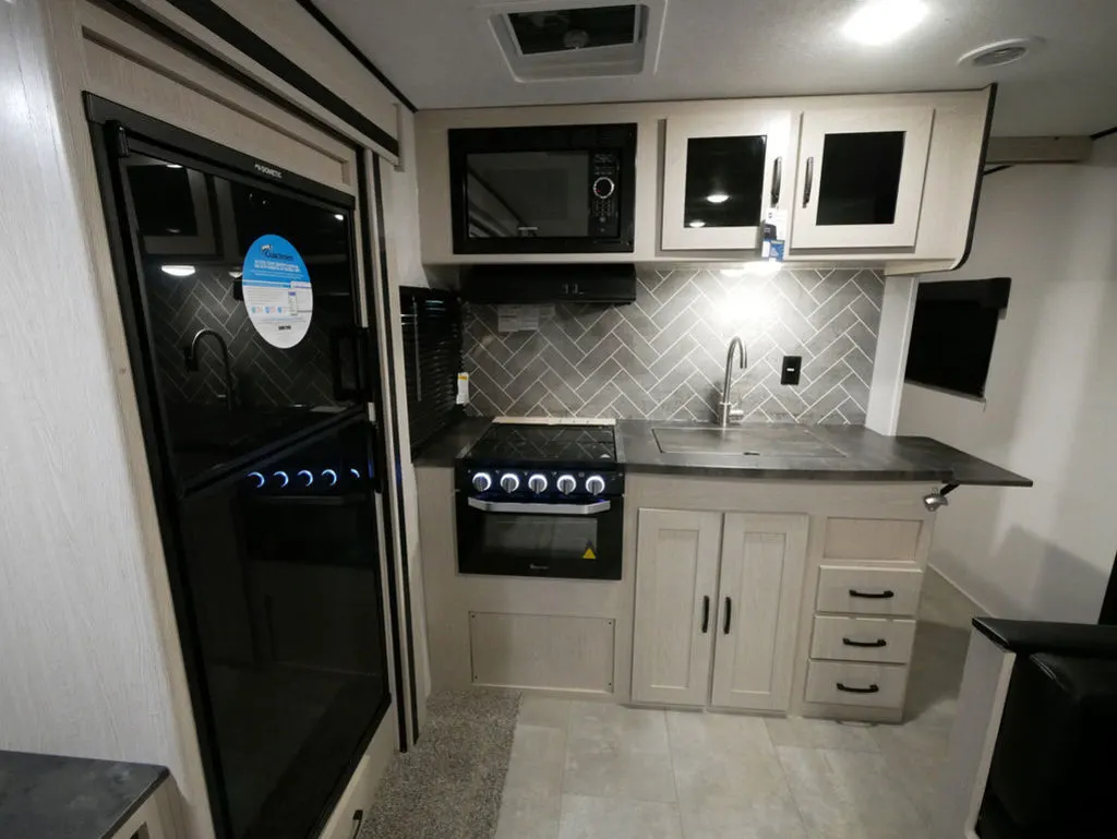 Kitchen with a gas range, fridge, oven, sink and cabinets.