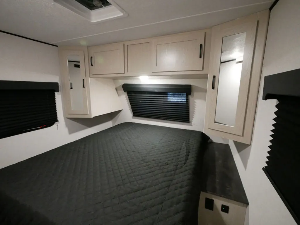 Bedroom with a queen size bed, overhead cabinets and shirt closets.