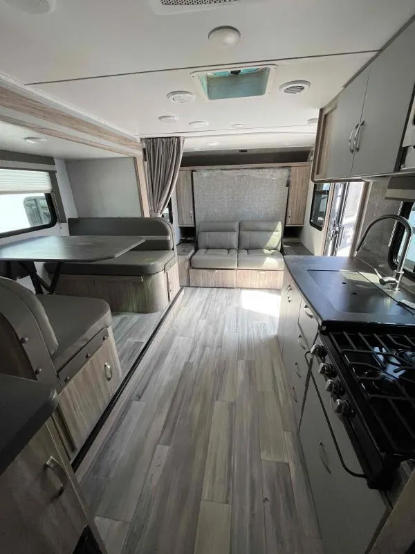 Interior view of the RV with a dinette, living space and a kitchen.