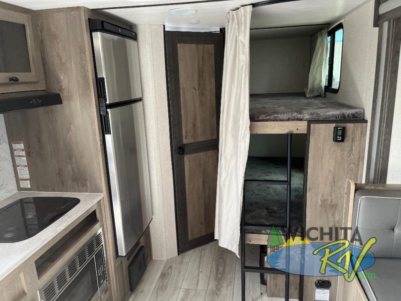 Interior view of the RV with a dinette, bedroom and a kitchen.