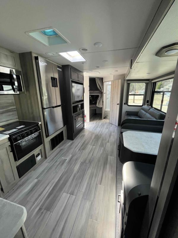 Interior view of the RV with a dinette, living space and a kitchen.