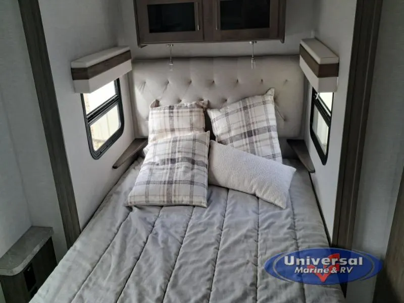 Bedroom with a queen size bed and overhead cabinets.