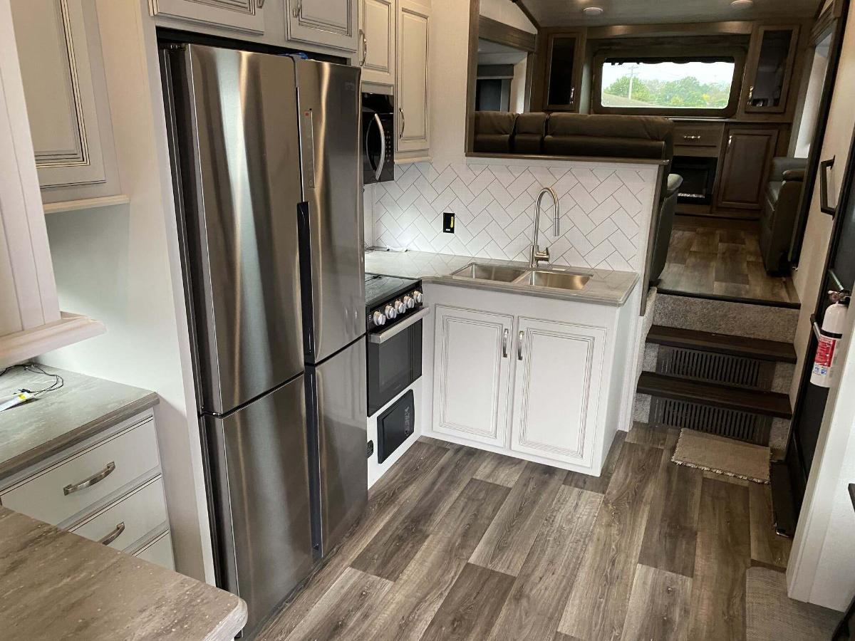 Kitchen with a gas range, fridge, oven, sink and cabinets.