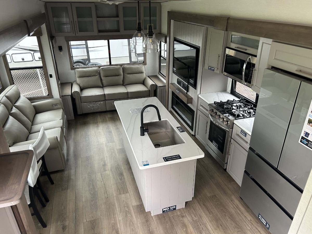 Interior view of the RV with a dinette, living space and a kitchen.