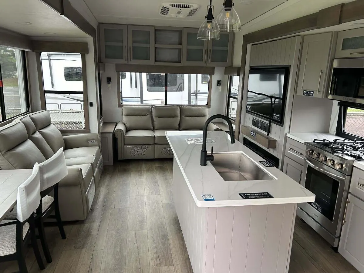 Interior view of the RV with a dinette, living space and a kitchen.