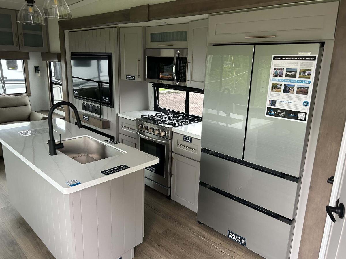 Kitchen with a gas range, fridge, oven, sink and cabinets.