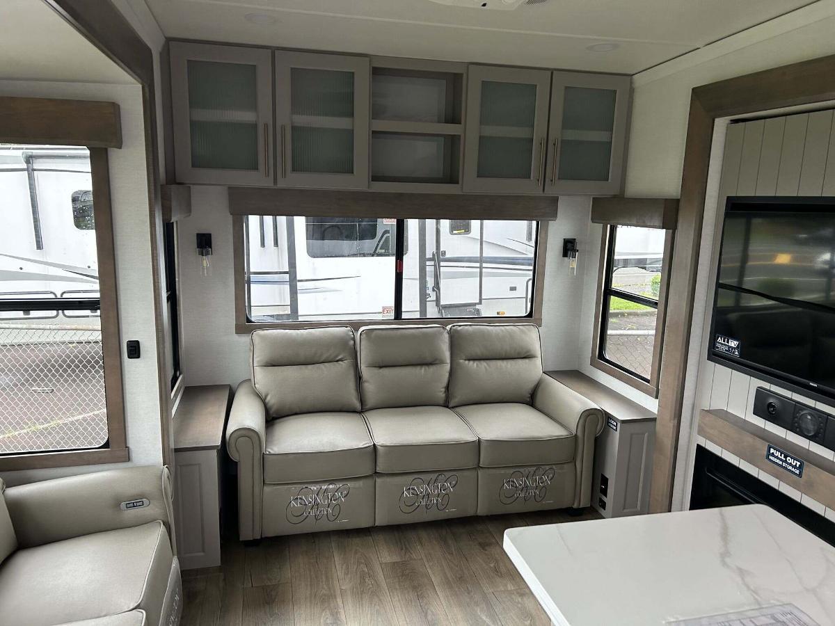 Living space with leather seats and overhead cabinets.  