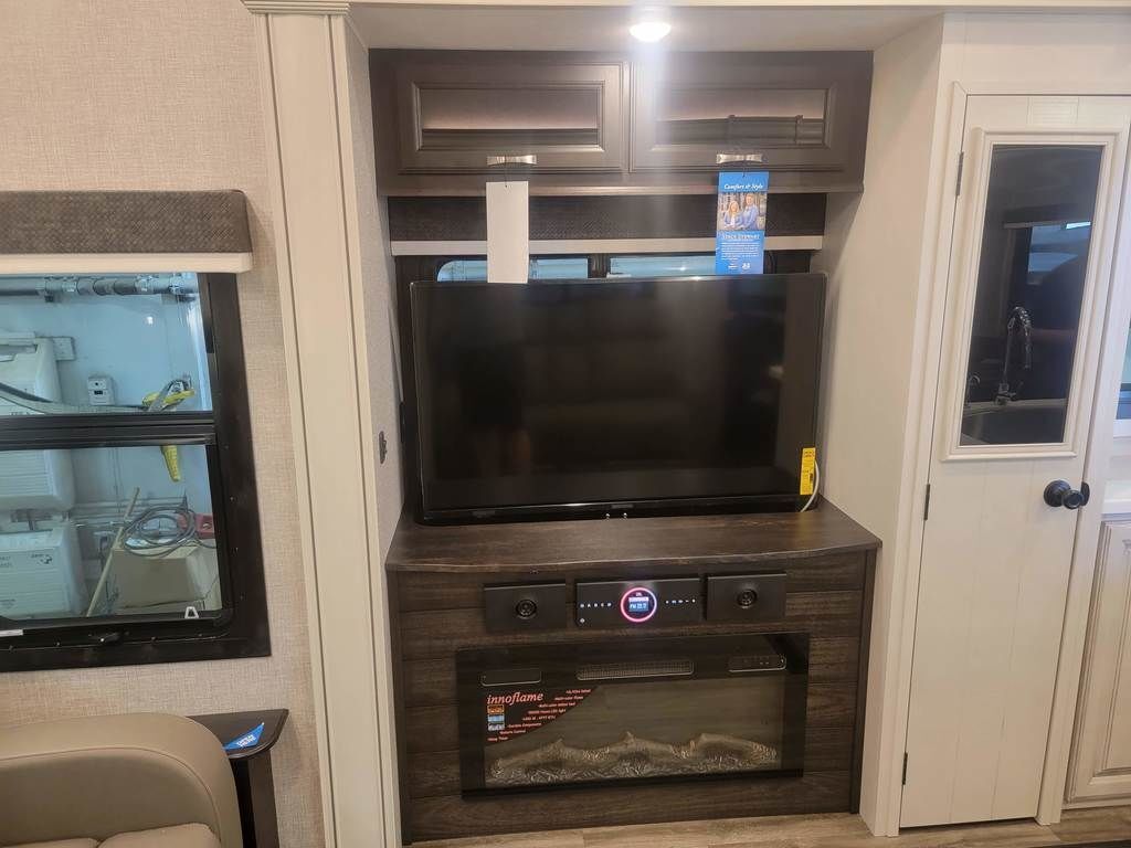 Entertainment center with a TV and a fireplace.