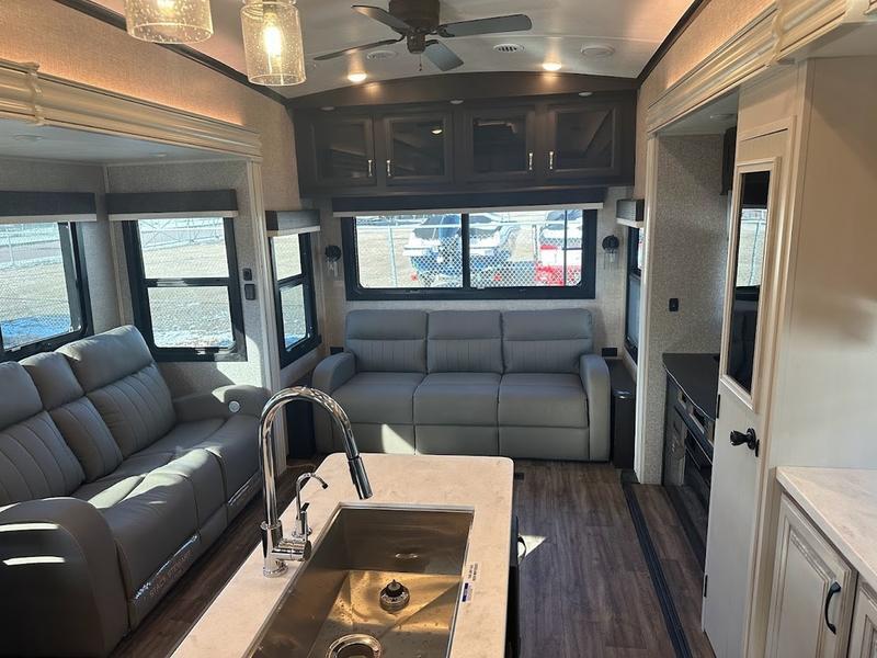 Living space with leather seats and overhead cabinets.