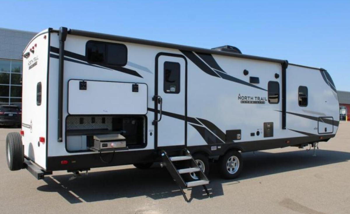 Side view of the RV with an outdoor kitchen.