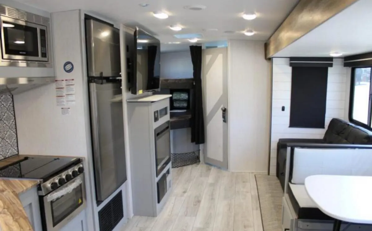 Interior view of the RV with a dinette, living space and a kitchen.