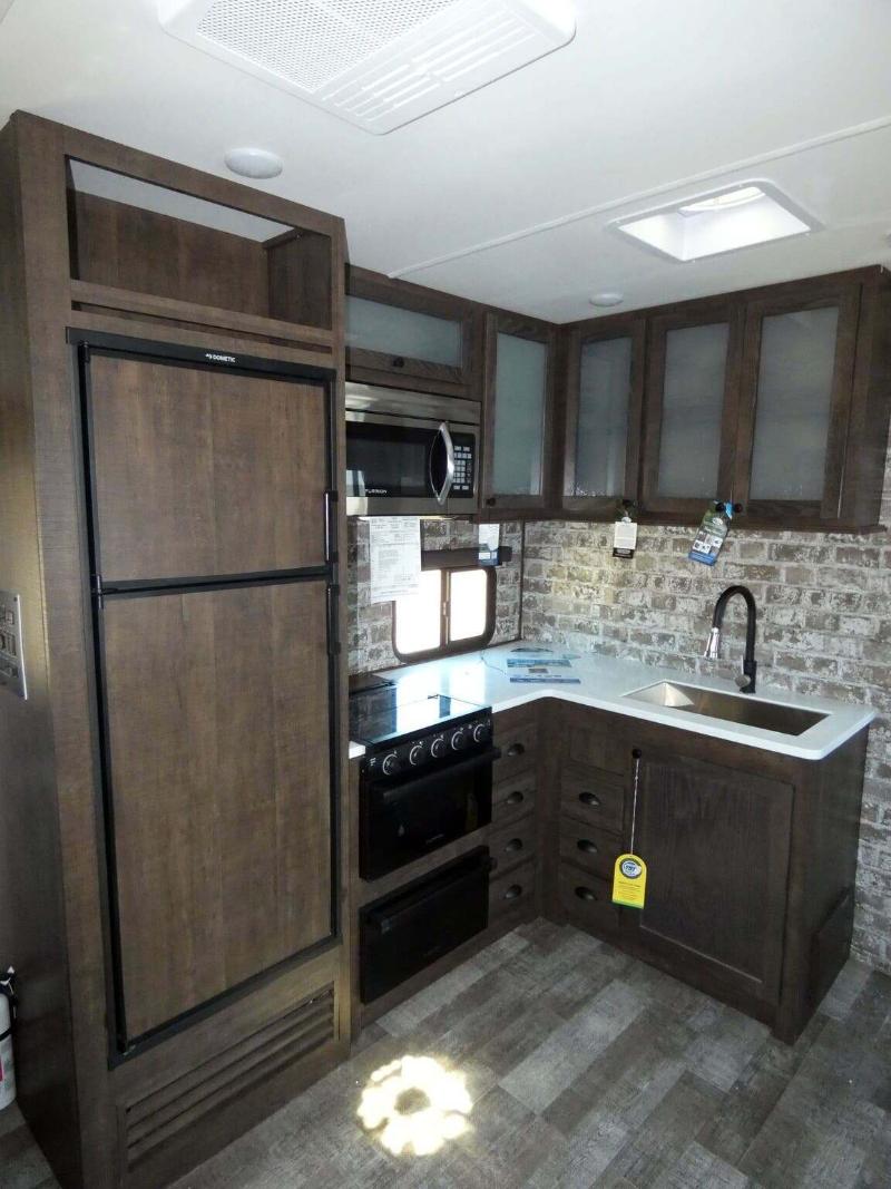 Kitchen with a gas range, fridge, oven, sink and cabinets.