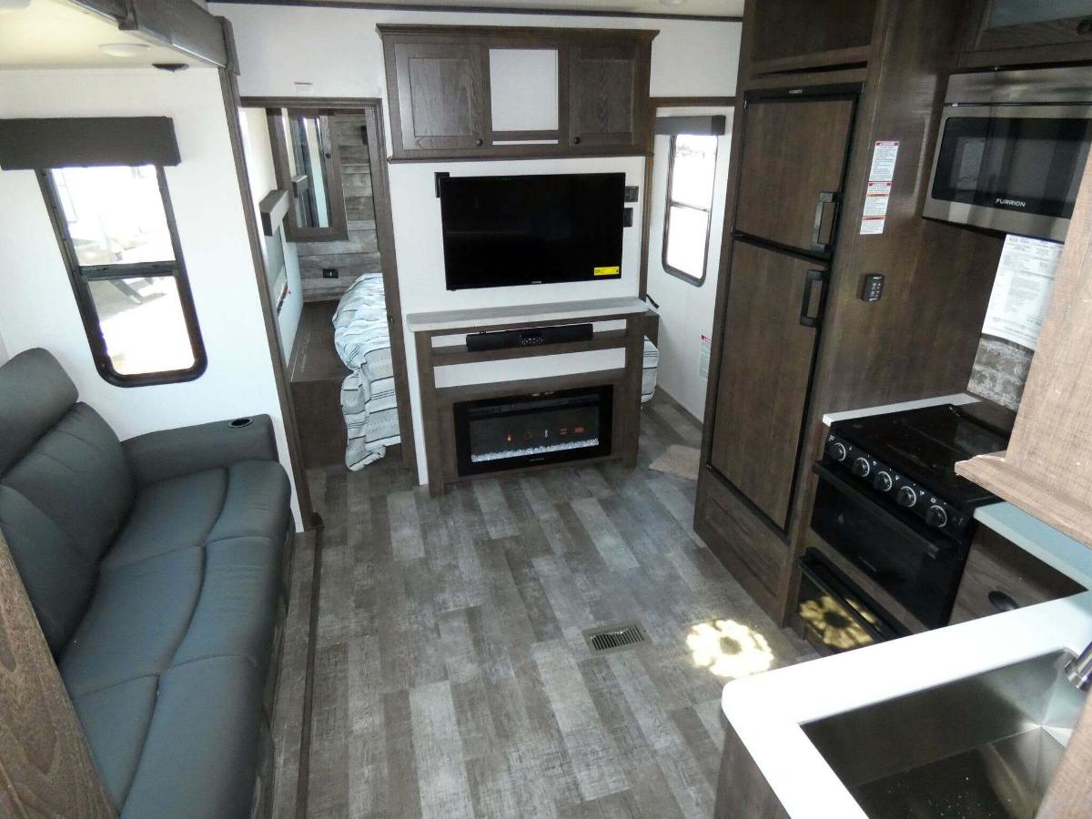 Interior view of the RV with an entertainment, living space and a kitchen.