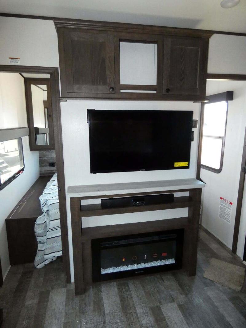 Entertainment center with a TV and a fireplace.