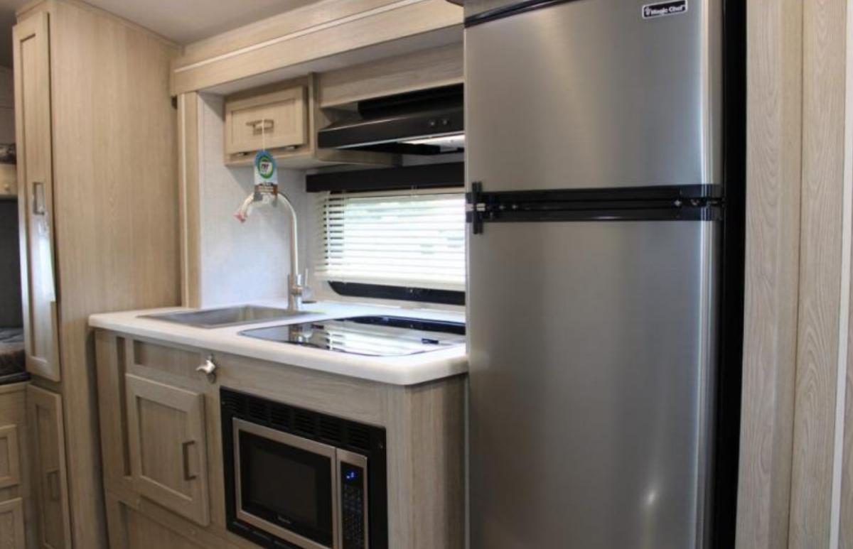 Kitchen with a gas range, fridge, sink and cabinets.