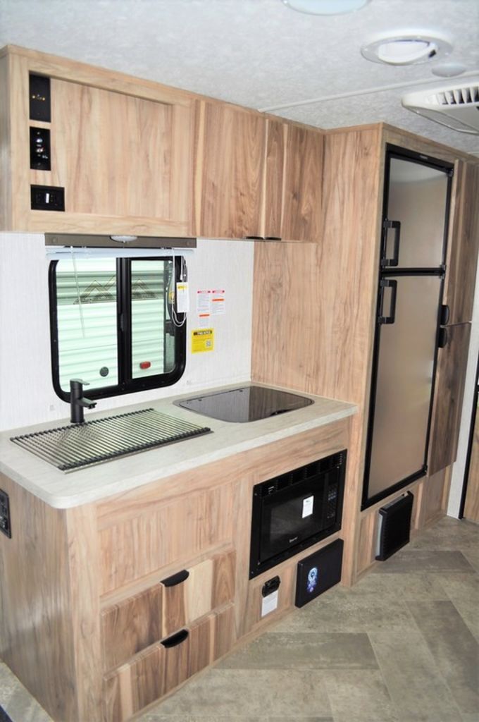 Kitchen with a gas range, fridge, sink and cabinets.