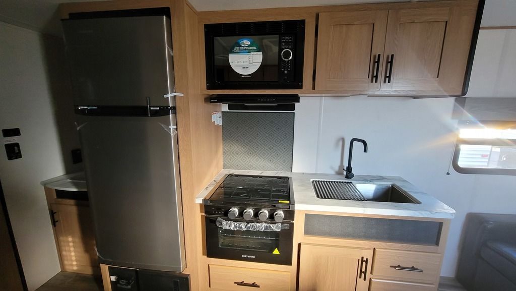 Kitchen with a gas range, fridge, oven, sink and cabinets.