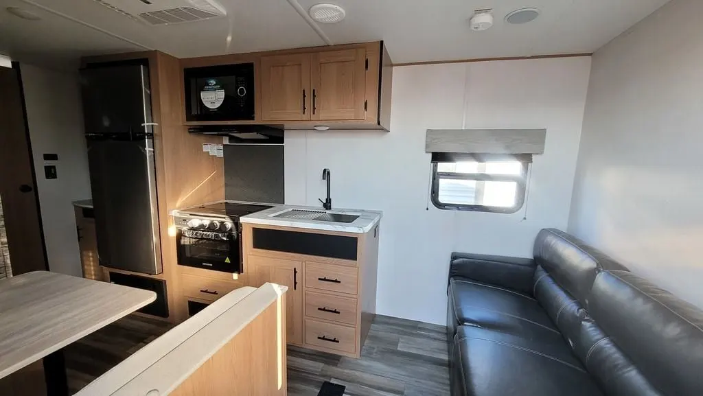 Interior view of the RV with a dinette, living space and a kitchen.