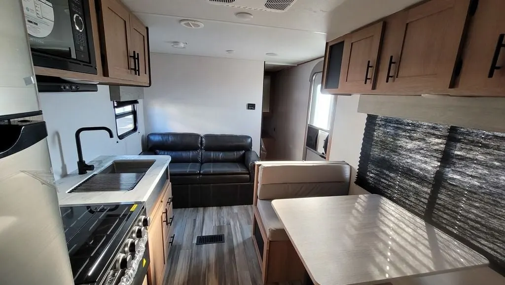 Interior view of the RV with a dinette, living space and a kitchen.