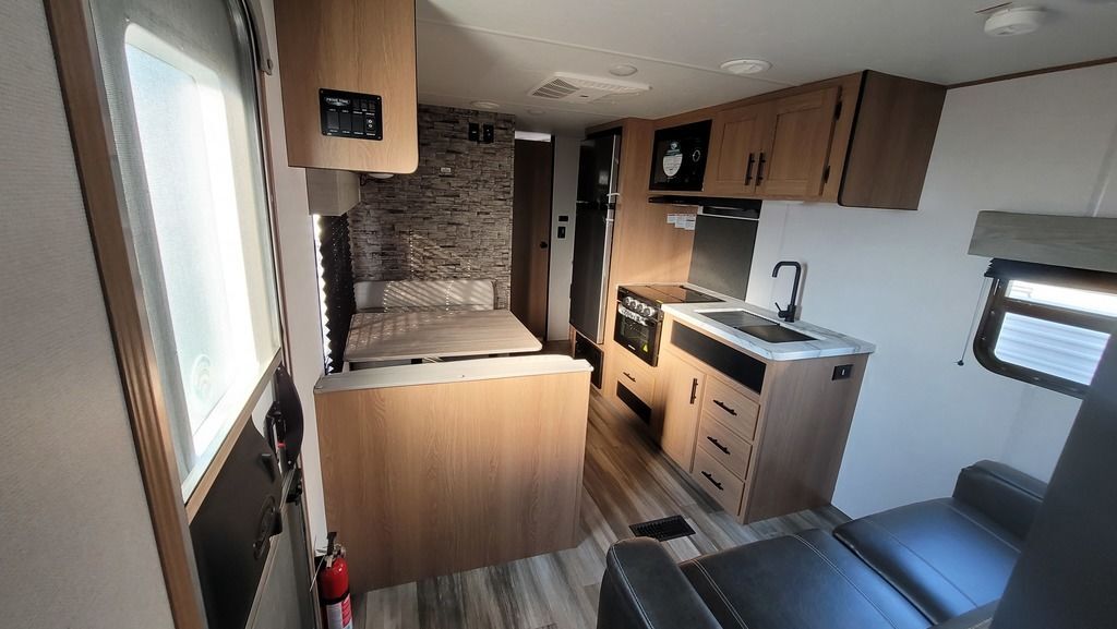 Interior view of the RV with a dinette, living space and a kitchen.