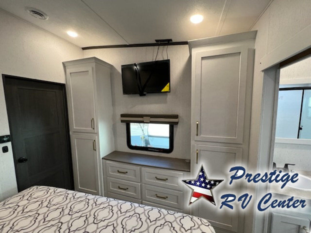 Bedroom with a king size bed, TV and cabinets.