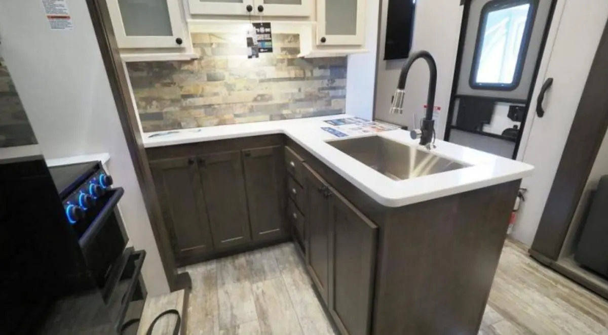 Kitchen with a gas range, sink and cabinets.