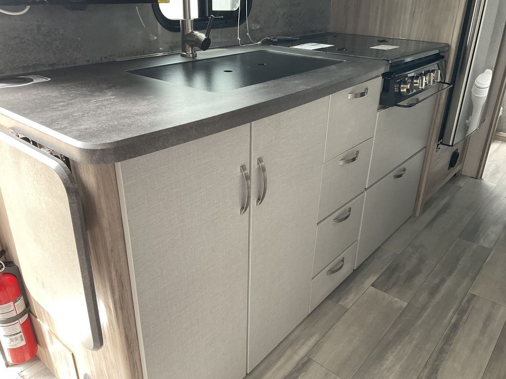 Kitchen with a gas range, sink and cabinets.