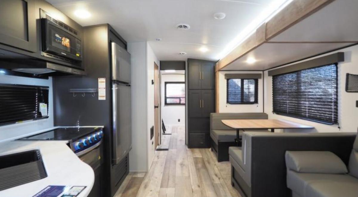 Interior view of the RV with a dinette, living space and a kitchen.