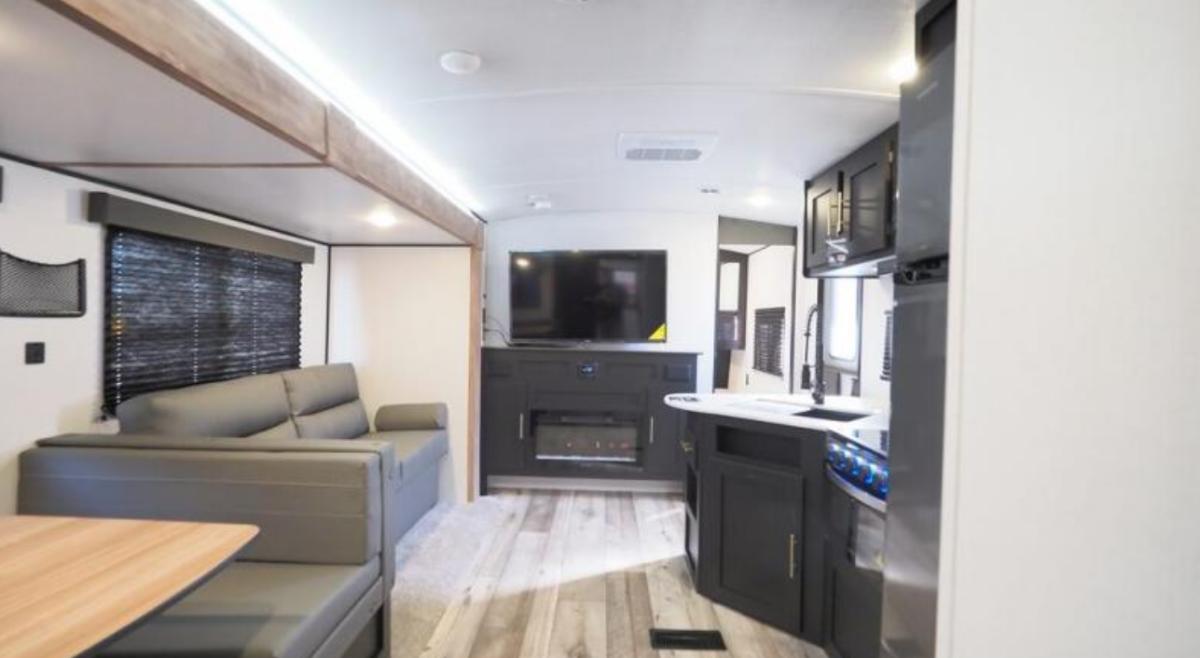 Interior view of the RV with a dinette, living space and a kitchen.