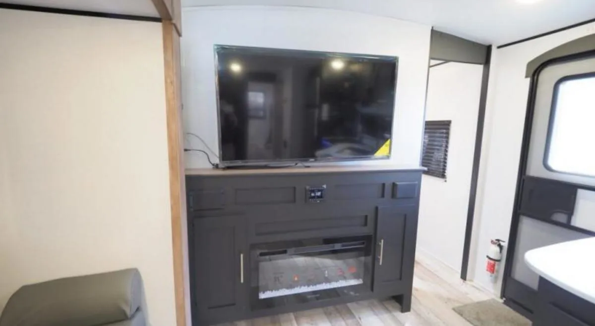 Entertainment center with a TV and a fireplace.