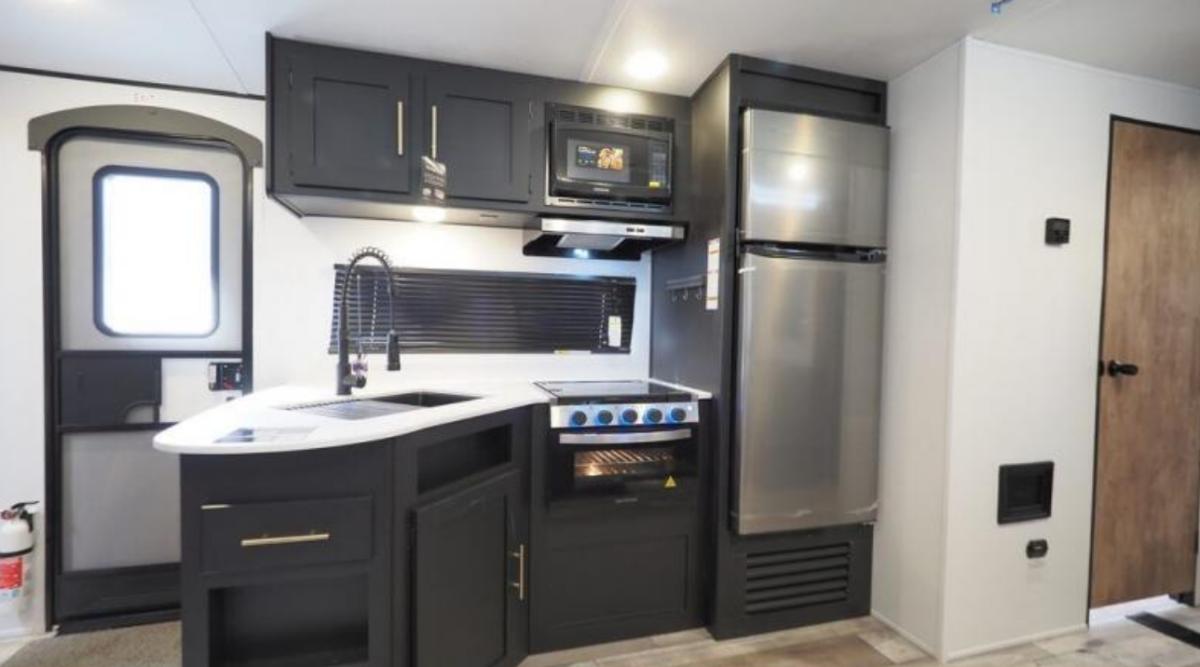 Kitchen with a gas range, fridge, oven, sink and cabinets.