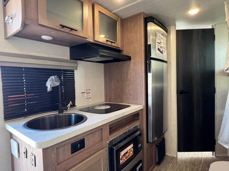 Kitchen with a gas range, fridge, sink and cabinets.