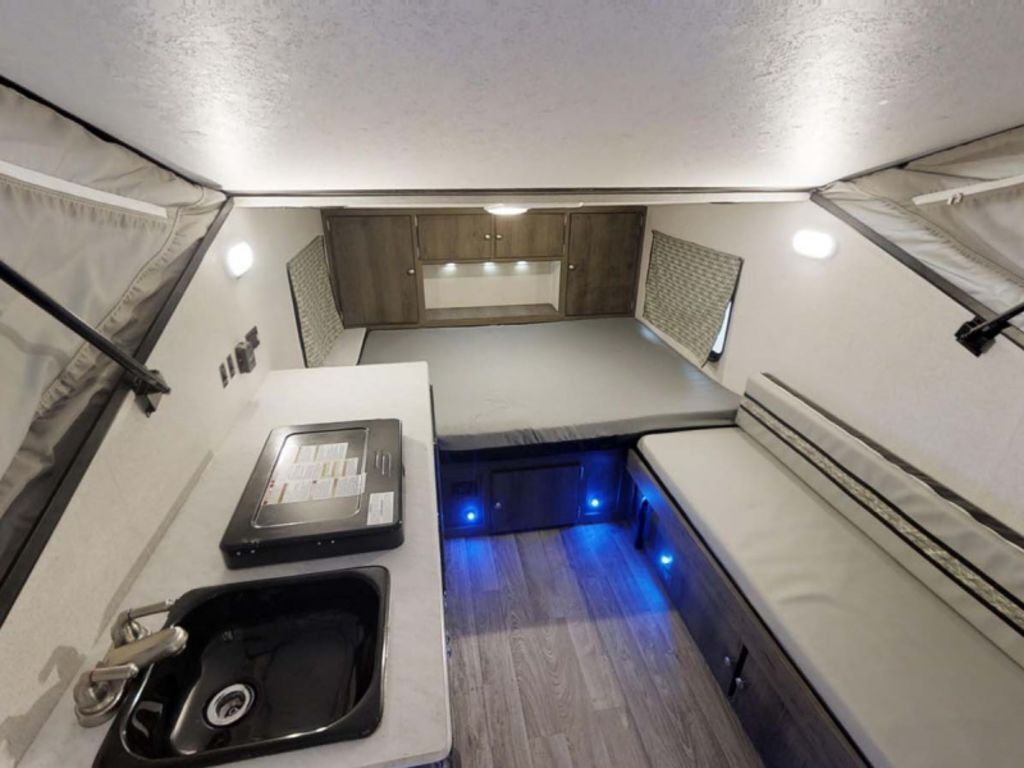 Interior view of the RV with a bedroom, living space and a kitchen.