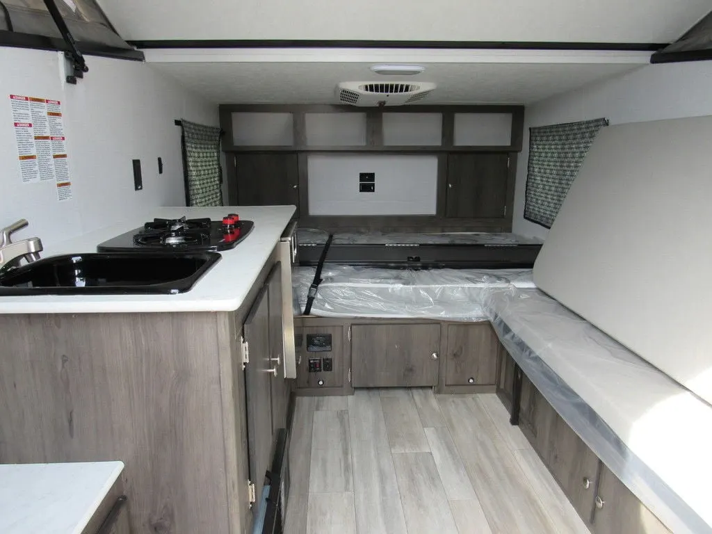 Interior view of the RV with a bedroom, living space and a kitchen.