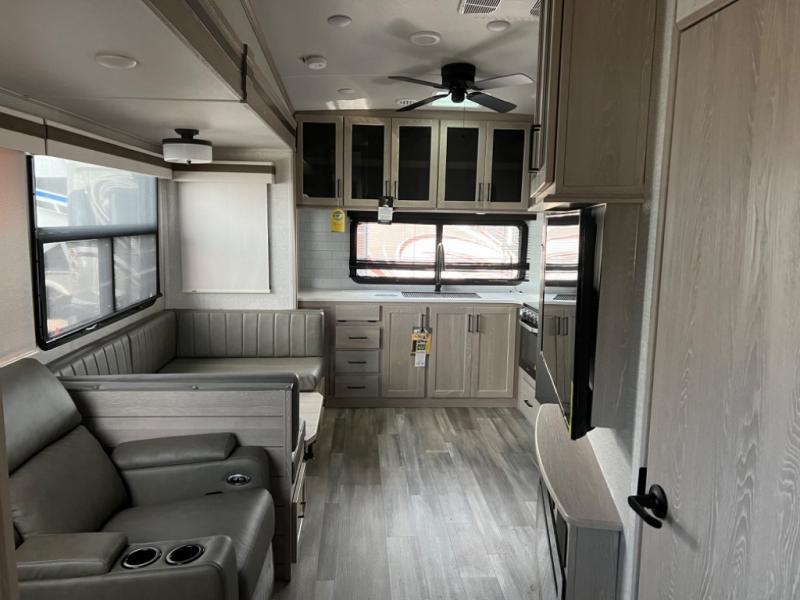 Interior view of the RV with a dinette, living space and a kitchen.