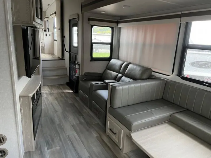 Interior view of the RV with a dinette and a living space.