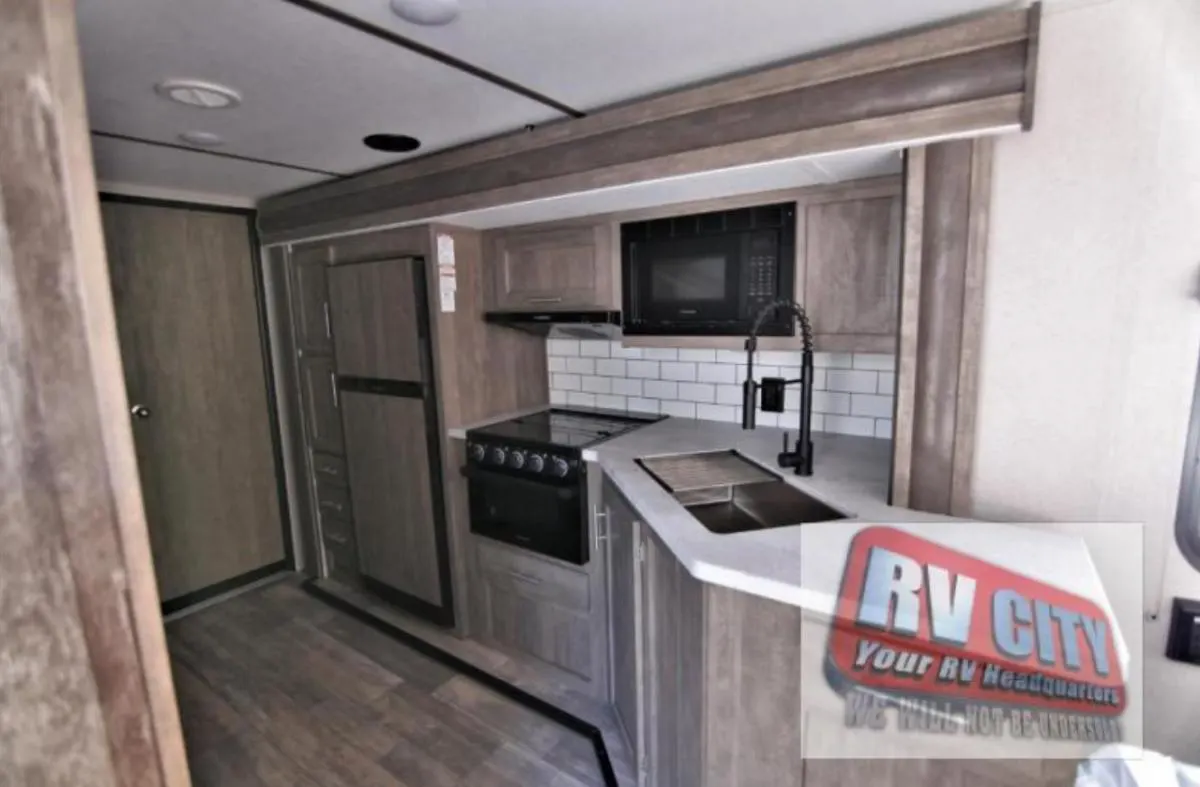 Kitchen with a gas range, fridge, oven, sink and cabinets.