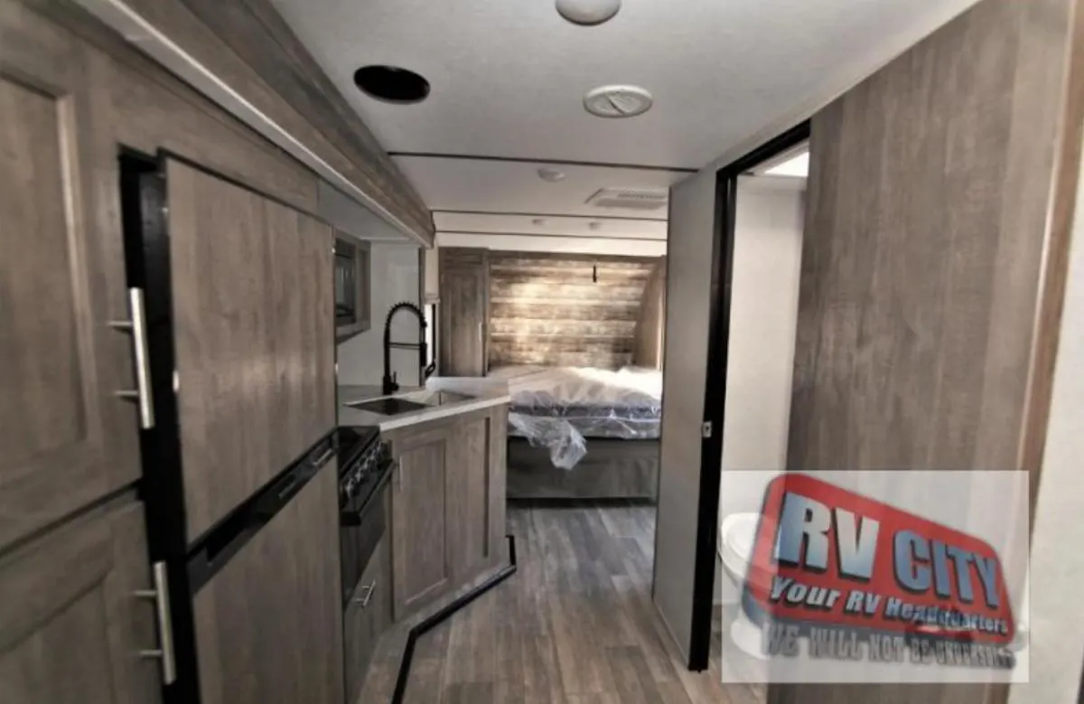 Interior view of the RV with a bedroom and a kitchen.