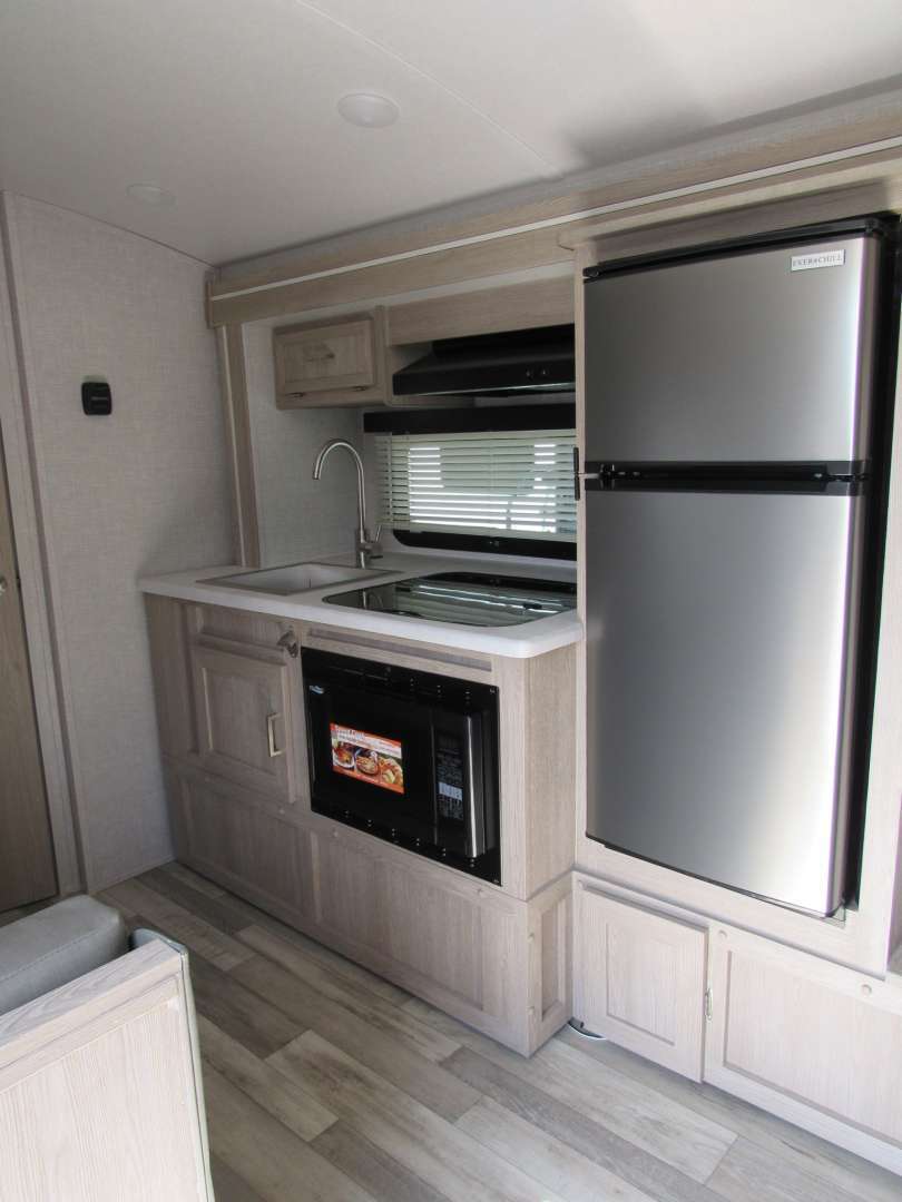 Kitchen with a gas range, fridge, sink and cabinets.