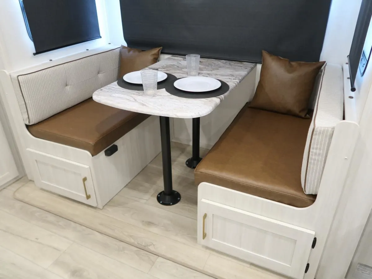 Dinette with leather seats and pull-out storage drawers.