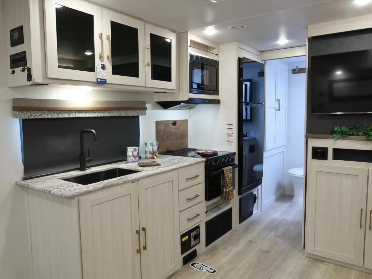 Kitchen with a gas range, fridge, oven, sink and cabinets.