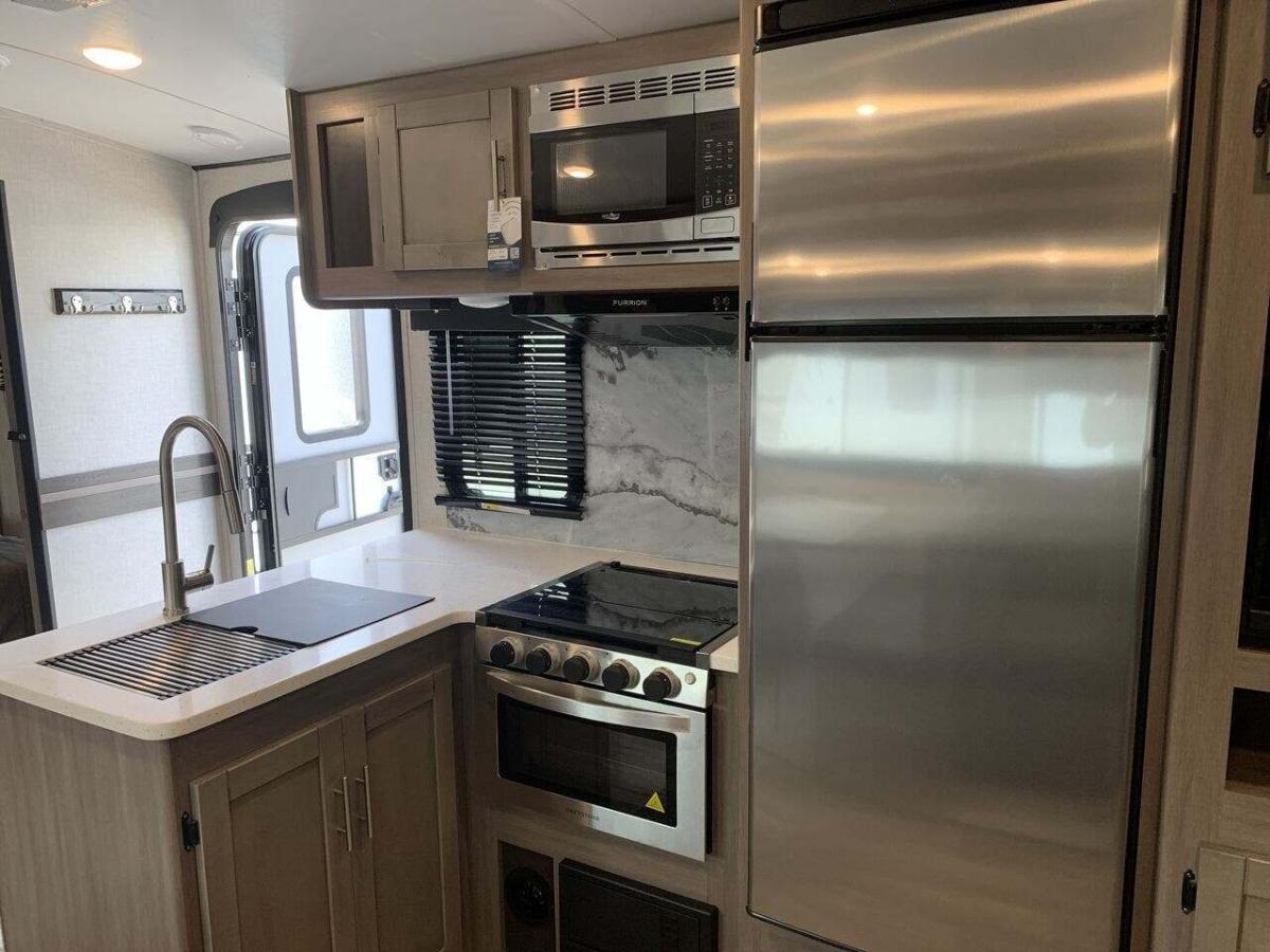 Kitchen with a gas range, fridge, oven, sink and cabinets.