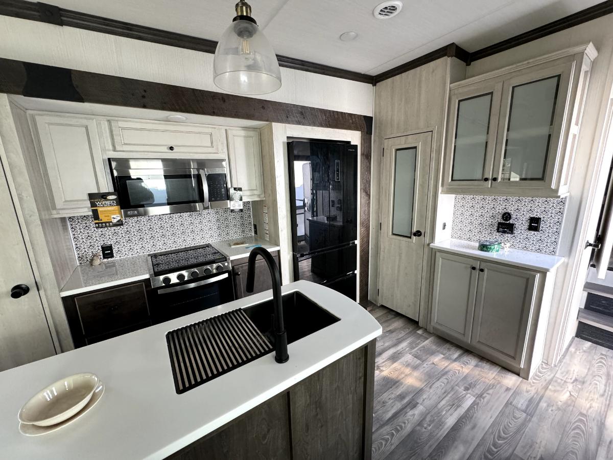 Kitchen with a gas range, fridge, oven, sink and cabinets.