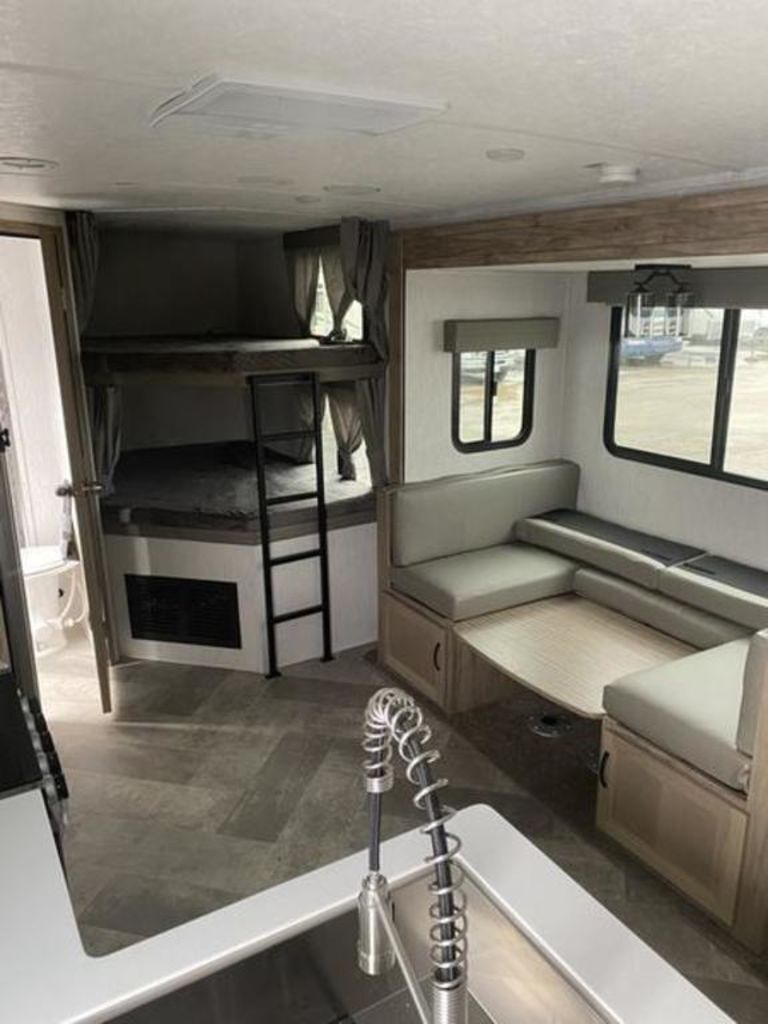 Interior view of the RV with a dinette, bedroom and a kitchen.