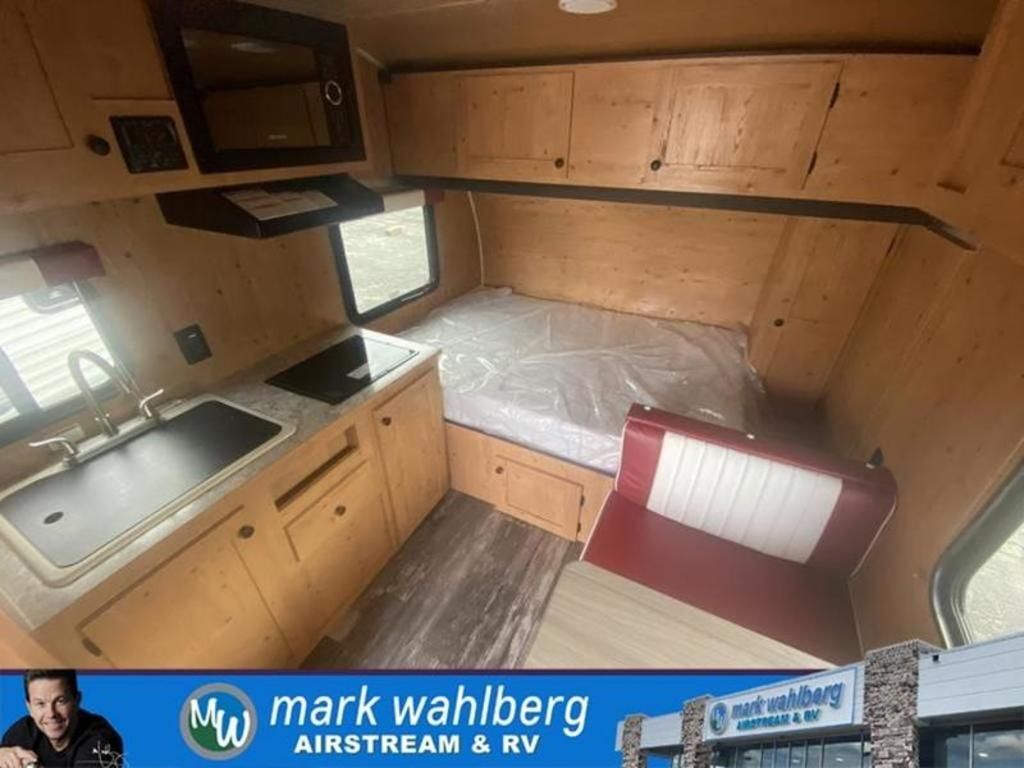 Interior view of the RV with a dinette, bedroom and a kitchen.