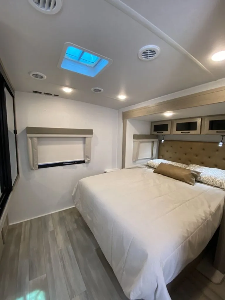 Bedroom with a queen size bed and overhead cabinets.