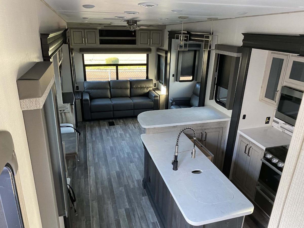 Interior view of the RV with a dinette, living space and a kitchen.