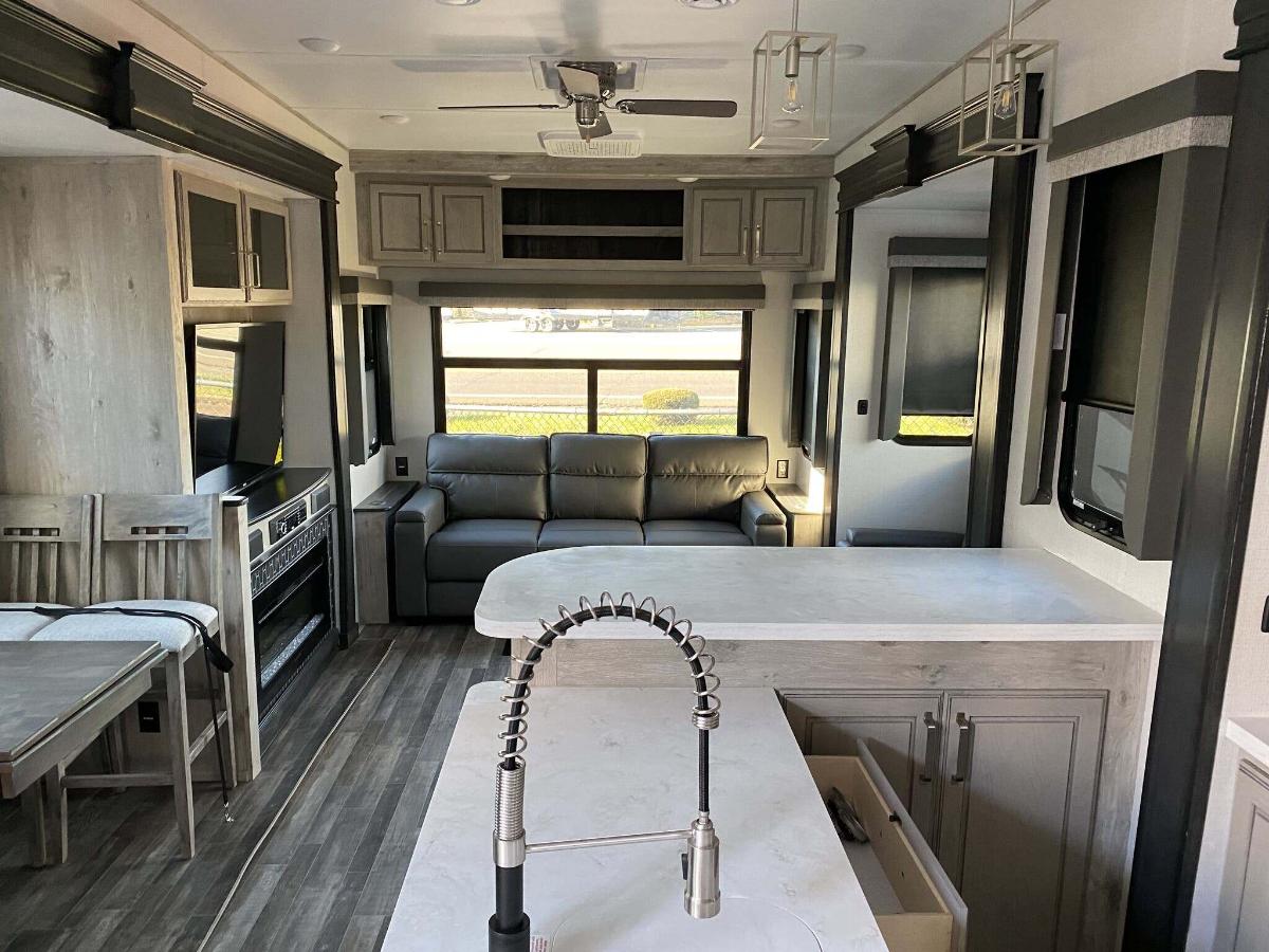 Interior view of the RV with a dinette, living space and a kitchen.